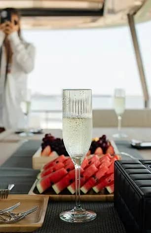 An image of a glass of champaign and a watermelon dish